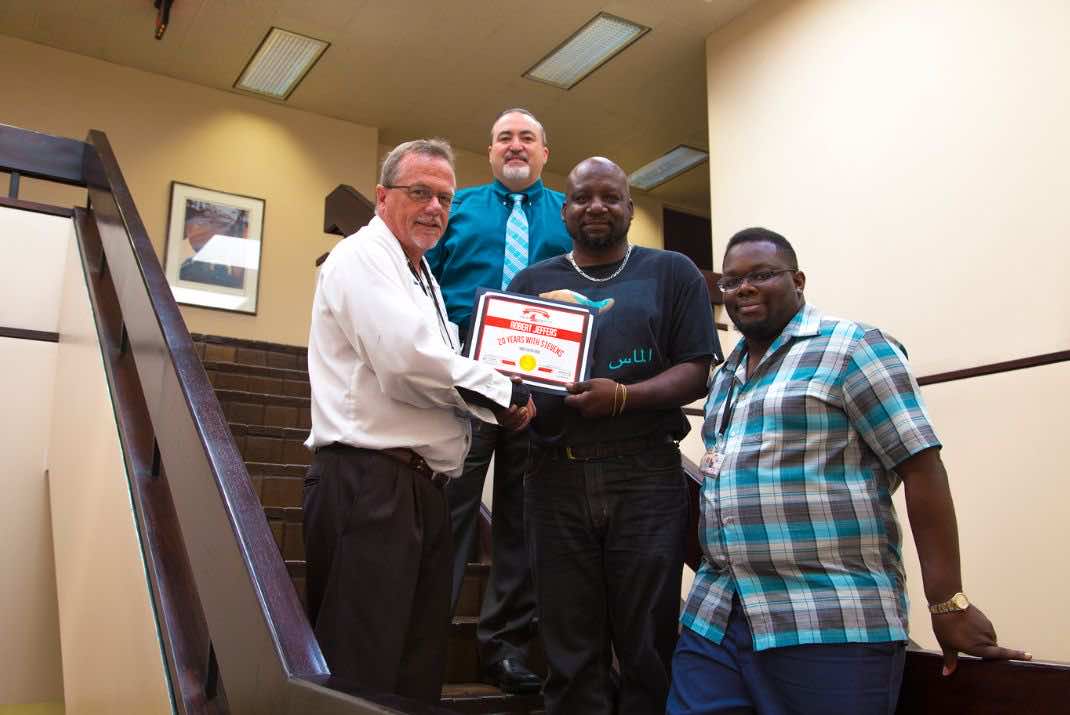 Image of four men, Robert Jeffers holding 20 years of service award