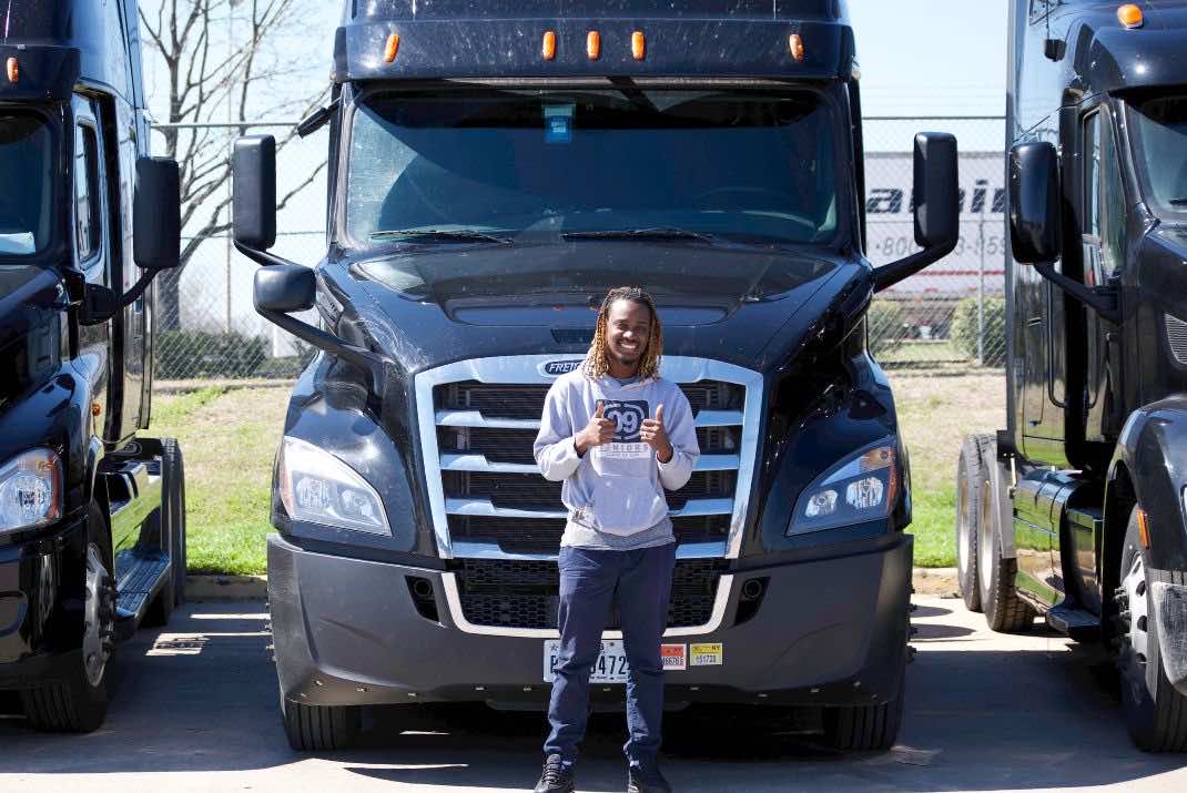 Image of Trucker Tony with his thumbs up in front of his truck