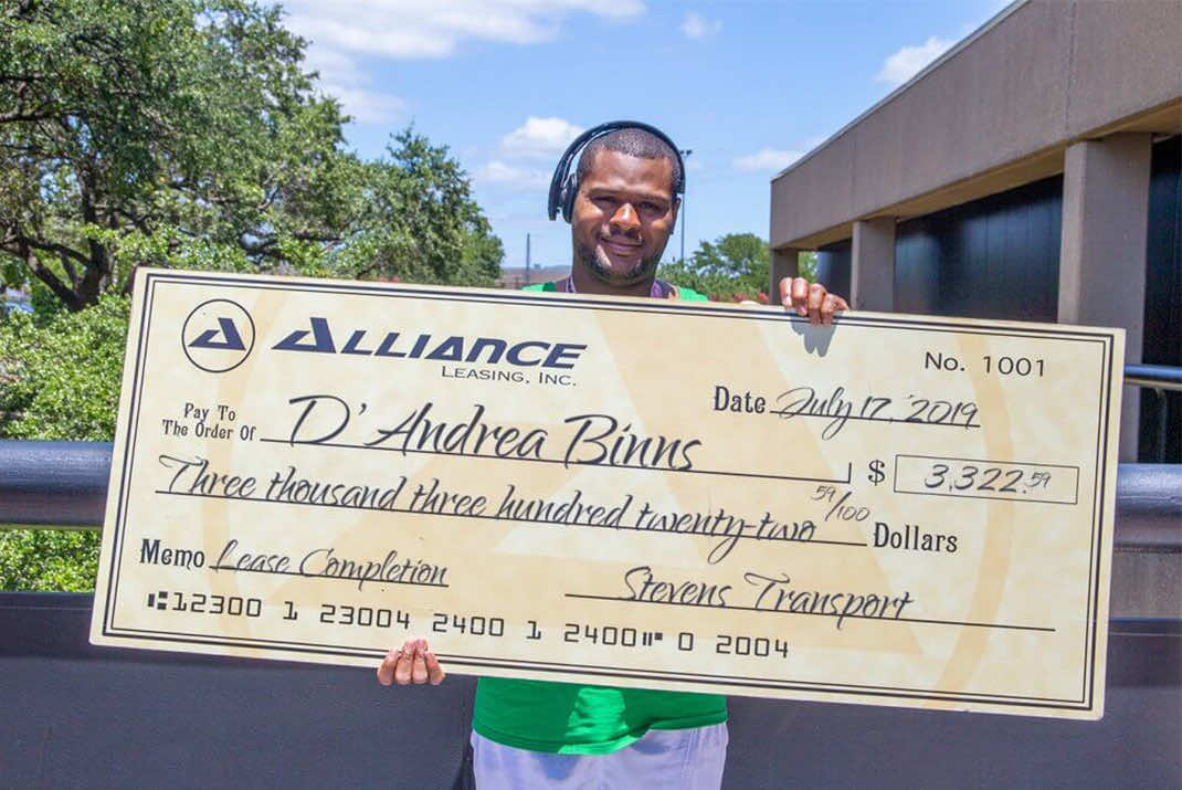 Image of D'Andre Binns holding large check