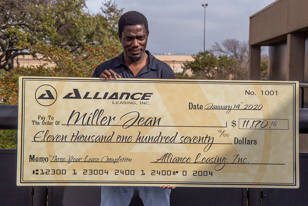 Image of Miller Jean holding large check