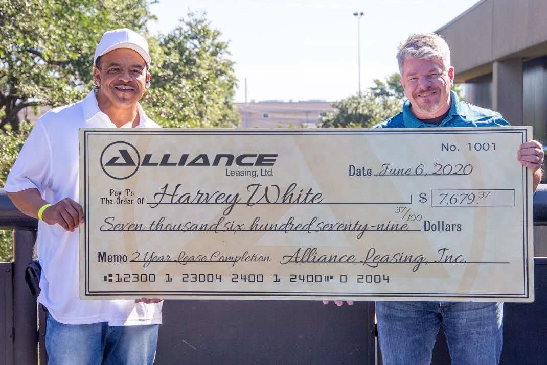Image of two men holding a large check, Harvey White on the left
