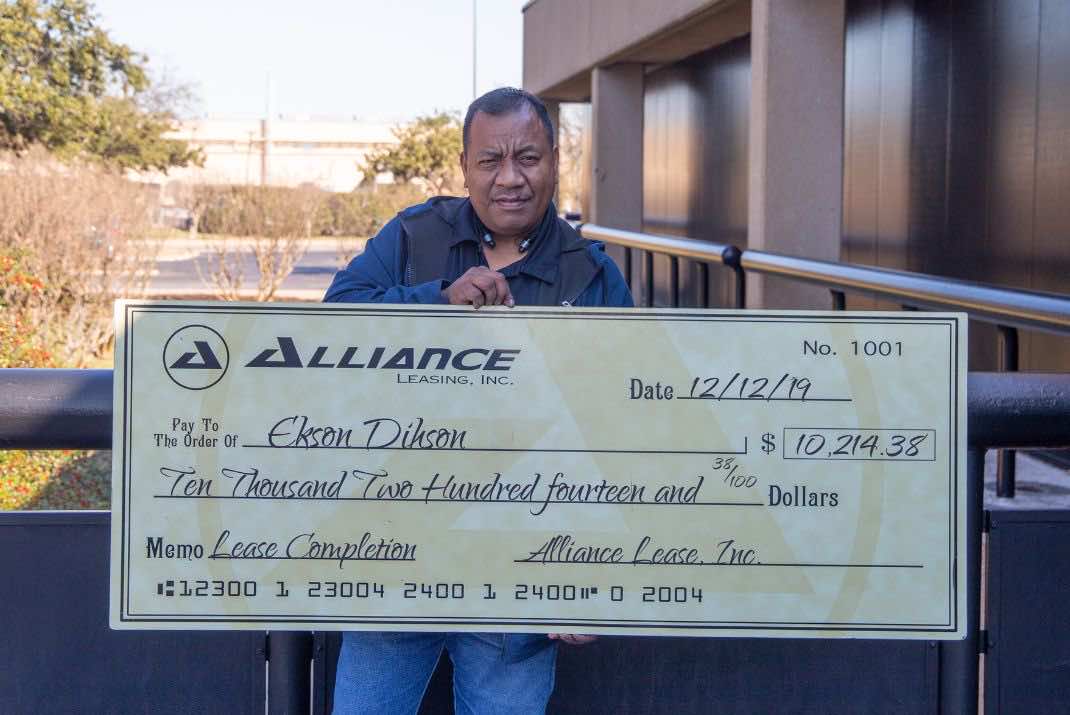 Image of Ekson Dihson holding large check
