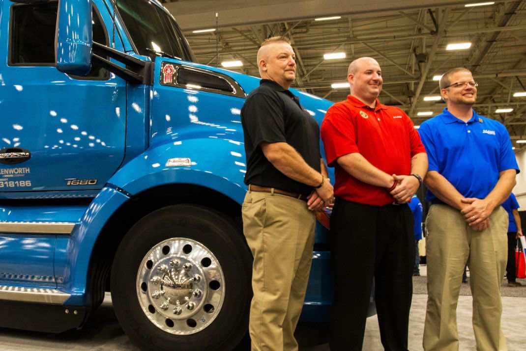 Image of three men standing in front of blue truck