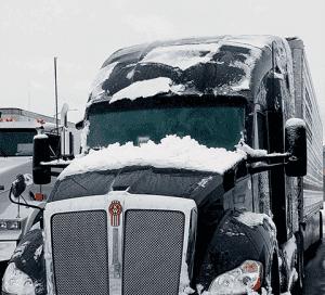 Image of black truck covered in snow