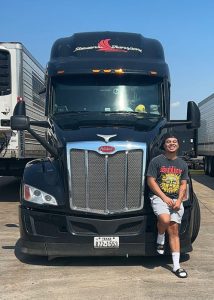 Thomas Tang standing in front of semi truck
