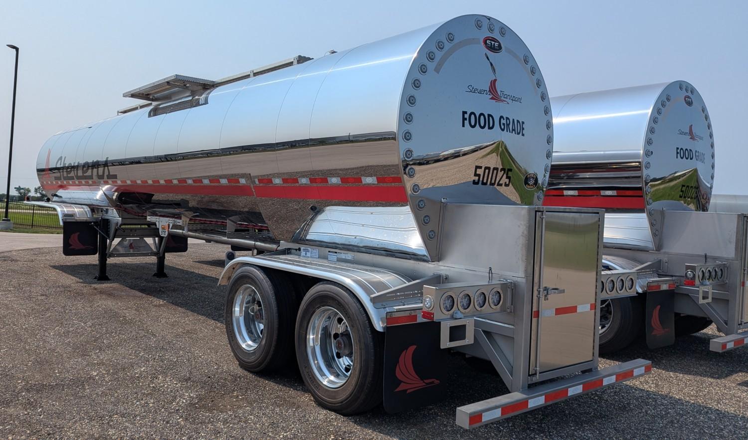 Close-up of the rear of a Stevens Transport food grade stainless steel tanker trailer showing the bolted end cap and undercarriage
