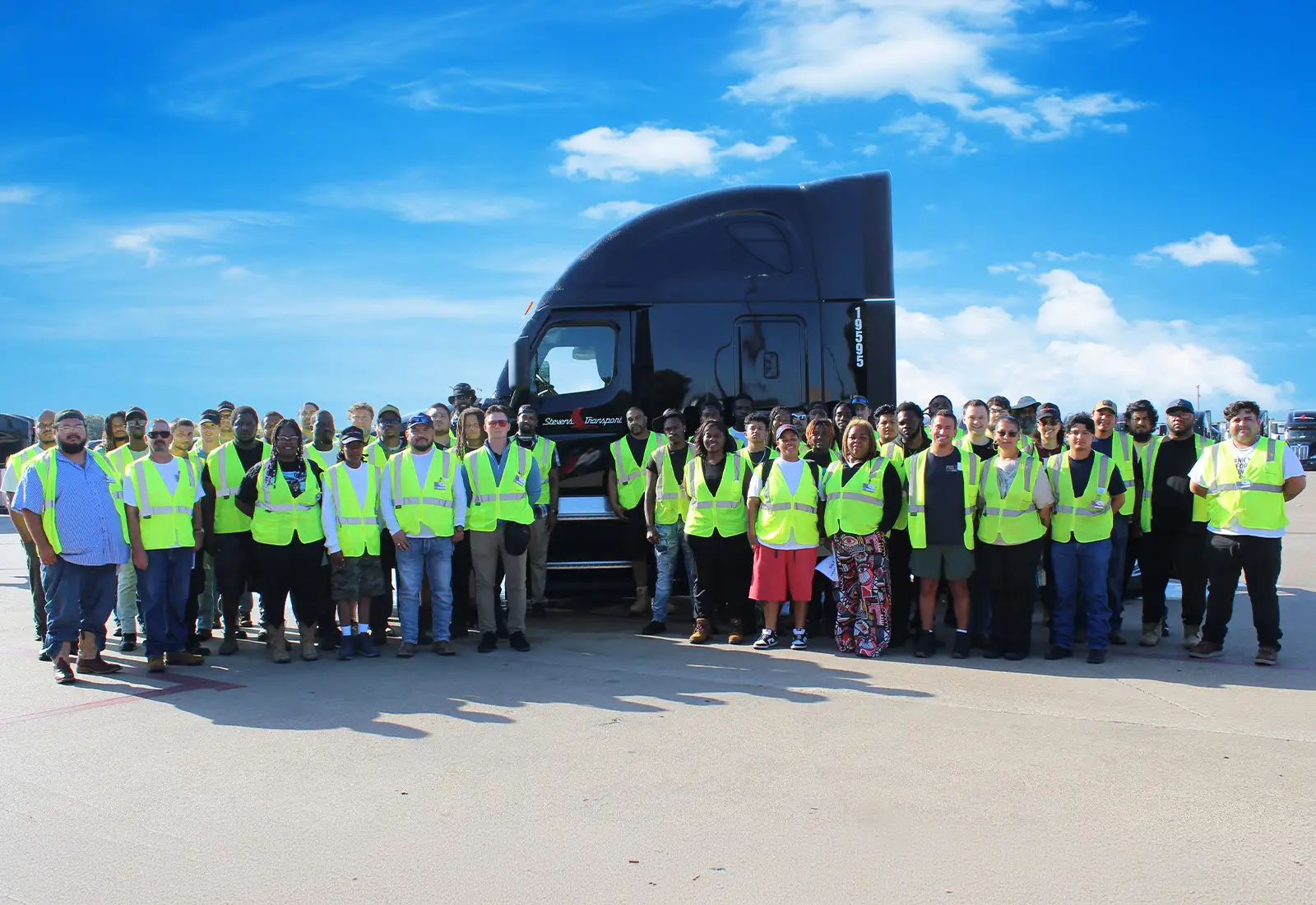Large group of CDL training graduates standing in front of Stevens Transport semi truck