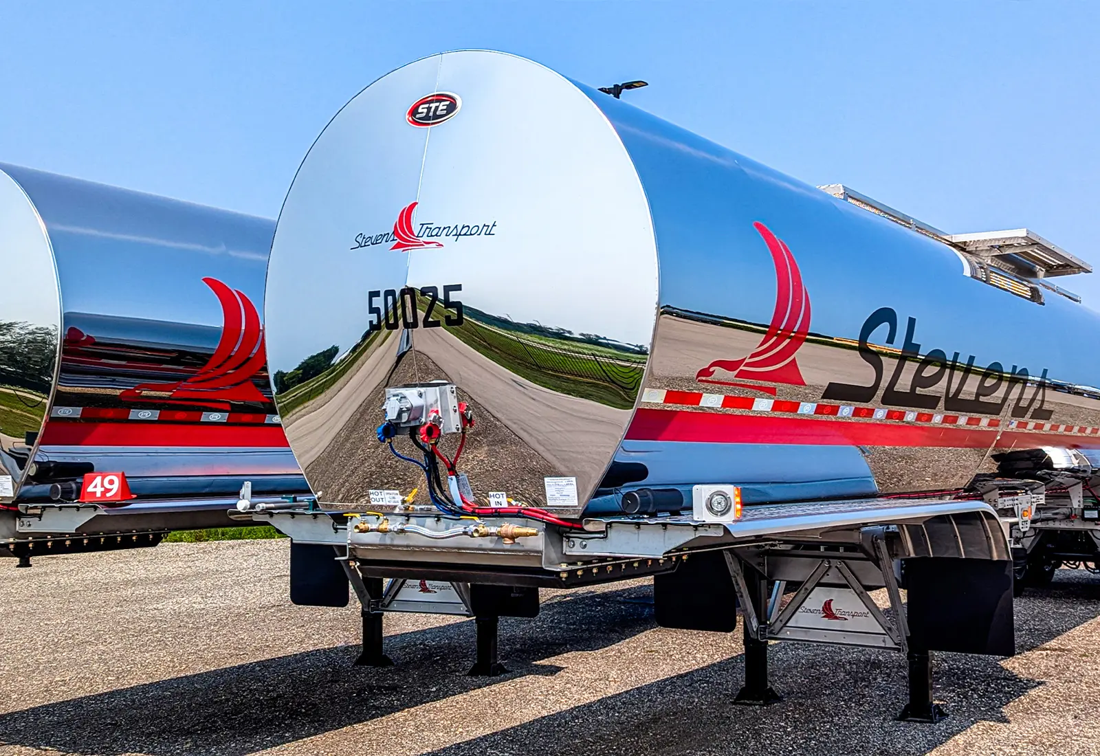 Two Stevens Transport food-grade tankers parked in gravel lot